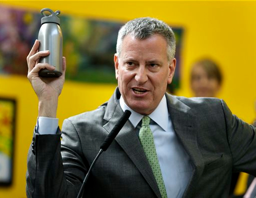 New York City mayor Bill de Blasio holds up a reusable water bottle as an example of a change he made for the environment during a news conference in the Bronx on Wednesday. New York City, in a far-reaching effort to limit its impact on the environment, marked Earth Day on Wednesday by announcing a plan to reduce its waste output by 90 percent by 2030. AP Photo/Seth Wenig