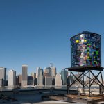 Brooklyn artist Tom Fruin’s solar-powered sculpture, “Watertower 3: R.V. Ingersoll,” is stationed at the roof of 334 Furman St., near Pier 5, in Brooklyn Bridge Park. Fruin is one of several artists/cultural groups to be awarded below-market space in DUMBO by Two Trees Management Co. Photo by Julienne Schaer