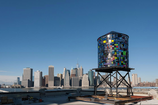 Brooklyn artist Tom Fruin’s solar-powered sculpture, “Watertower 3: R.V. Ingersoll,” is stationed at the roof of 334 Furman St., near Pier 5, in Brooklyn Bridge Park. Fruin is one of several artists/cultural groups to be awarded below-market space in DUMBO by Two Trees Management Co. Photo by Julienne Schaer