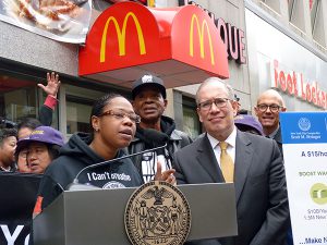 Raising the minimum wage in New York City to $15-per-hour would not only improve the lives of workers but would also benefit the city economically, New York City Comptroller Scott Stringer said on Monday. Shown: Chantelle Walker, a Papa John's employee, with Stringer on Fulton Street.  Photo by Mary Frost
