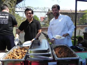Steven Dominguez (left) of the Wicked Monk bar-restaurant and Executive Chef Russell Titland serve pulled pork and chicken at the fundraiser. Eagle photo by Paula Katinas