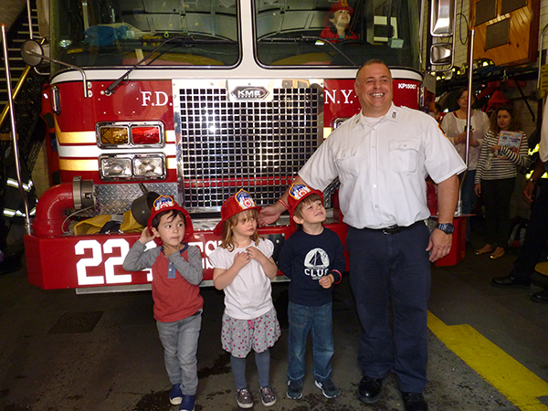 Engine Co. 224’s Captain Lawrence Garda shows the firetruck to (from left) Henrik Grubb, Elizabeth Pulter and Larson Svensson. Photos by Mary Frost