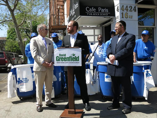 Councilmember David Greenfield (at podium) announces the new cleanup effort by the Doe Fund. At left is Doe Fund Founder George McDonald. At right is Community Board 12 District Manager Barry Spitzer. Photo courtesy of Greenfield’s office