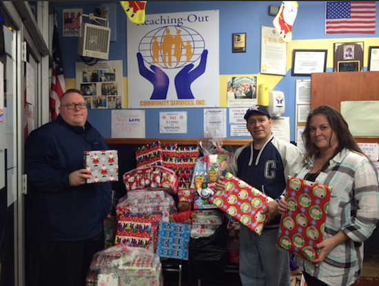 Robert Rising (left) and volunteer Jennifer Gammone deliver toys to Thomas Neve, executive director of Reaching-Out Community Services Inc. Photo courtesy Robert Rising