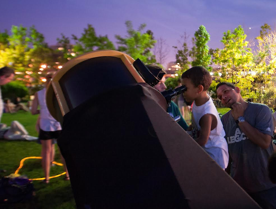 A young boy tests out a telescope during a Brooklyn stargazing event. Courtesy of the World Science Festival