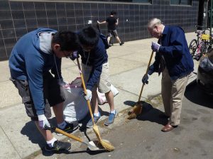 Assemblymember William Colton (right) and Jason Huang and Bowen Lu from Brooklyn Technical High School's Red Cross Club sweep litter off he sidewalks. Photo courtesy Colton's office