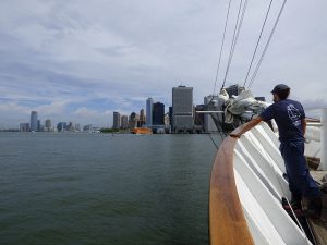 A sailor on the schooner Clipper City gazes over the port side to view what former Brooklyn Eagle editor Walt Whitman called our beautiful city “of hurried and sparkling waters . . . of spires and masts!” Photo by Mary Frost
