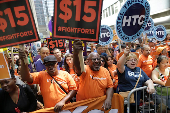 Activists cheer during a rally after the New York Wage Board endorsed a proposal to set a $15 minimum wage for workers at fast-food restaurants with 30 or more locations, Wednesday, July 22, in New York. The increase would be phased in over three years in New York City and over six years elsewhere. AP Photo/Mary Altaffer