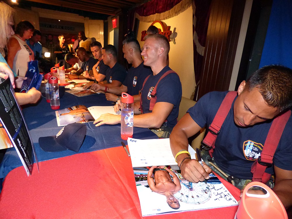 The buffest firefighters in New York take the time to autograph this year’s FDNY 2016 Calendar of Heroes. Photo by Mary Frost