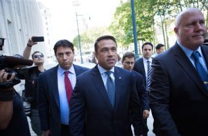 Former U.S. Rep. Michael Grimm, center, arrives ahead of his sentencing at Brooklyn federal court on Friday. Grimm pleaded guilty late last year to aiding in filing a false tax return, a charge that stemmed from an investigation into the Staten Island Republican's campaign financing. AP Photo/Kevin Hagen