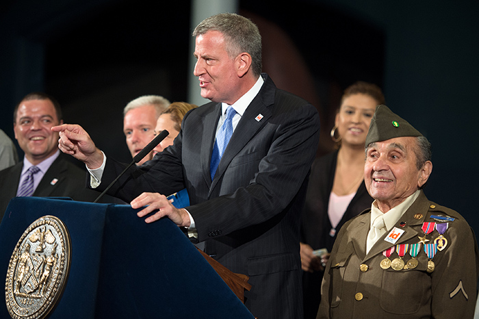 Mayor Bill de Blasio, center, discusses the success of New York City’s municipal ID card. Right: Private Luke Gasparre, age 91.  Photo courtesy of the Office of the Mayor