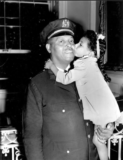 In this Sept. 4, 1941 file photo, Lt. Samuel Battle gets a kiss from his 4-year-old granddaughter, Yvonne, at City Hall, where he was sworn in as the city's first black parole commissioner.  AP Photo, File