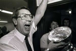 In this May 17, 1983, file photo, New York Islanders coach Al Arbour celebrates in the locker room as he holds the Stanley Cup after the Islanders won their fourth cup in a row, beating the Edmonton Oilers 4-2 to sweep the series at Nassau Coliseum. Arbour, who ranks as the NHL's second-most winningest coach, has died, team officials announced Friday. He was 82. The cause of death is unclear, though Arbor was battling a lengthy illness and had been living in Florida. AP Photo/Pool, File