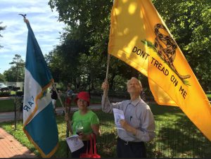A man holding the colonial-era flag, which reads “Don’t Tread On Me” and a woman next to him carrying a “DAR” (Daughters of the American Revolution) flag were both part of the Fort Greene ceremonies kicking off Battle Week. Eagle photos by Tom Moore