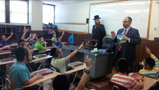 State Sen. Simcha Felder tells students in a yeshiva summer day camp program that it’s important to wear a helmet while riding a bicycle. Photo courtesy of Felder’s office