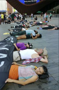 Protestors lay motionless on the pavement outside of Barclays Center on Sunday, marking the one-year anniversary of the shooting death of Michael Brown. Demonstrators maintained their silence for a few moments before rising and joining others, including some marching into Manhattan, for another rally later in the day. Among those marching were a dozen people carrying a giant banner reading "Black Lives Matter." AP Photo/Verena Dobnik