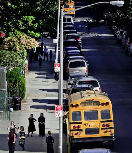 In this 2013 file photo, children gather on a sidewalk near school buses in Borough