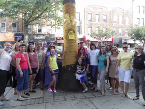 Members of Bay Ridge Cares placed a giant gold bow around a tree on Fifth Avenue in the “Go Gold Bay Ridge” campaign last year. Eagle file photo by Paula Katinas