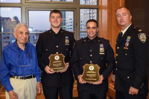 Officers Michael Chapman (second from left) and Maged Ibrahim (second from right) were honored as Cops of the Month by Leslie Lewis (left), president of the 84th Precinct Community Council, and Capt. Sergio Centa for their work in helping to reduce crime in Brooklyn Bridge Park. Eagle photos by Rob Abruzzese.