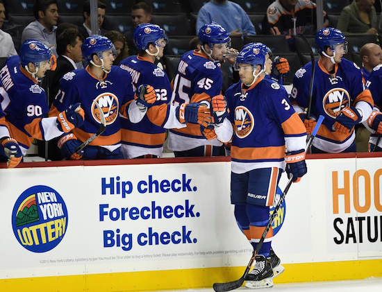 Islanders defenseman Travis Hamonic gets congratulations from his teammates after scoring what proved to be the game-winning goal in New York’s 2-1 exhibition victory over New Jersey at Downtown’s Barclays Center on Wednesday night. AP photo