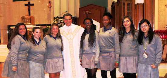 The Rev. Msgr. David Cassato congratulates the new Eucharistic ministers from Bishop Kearney High School. Pictured with Cassato are: Gianna Caratenuto, Allison Sisto, Amanda Potter, Esther Nduwimana, Neesha Isaac, Samantha Rubino and Emily Luong (left to right). Another student, Jasmine Ali, was unable to attend the installation mass. Photo courtesy of Bishop Kearney High School