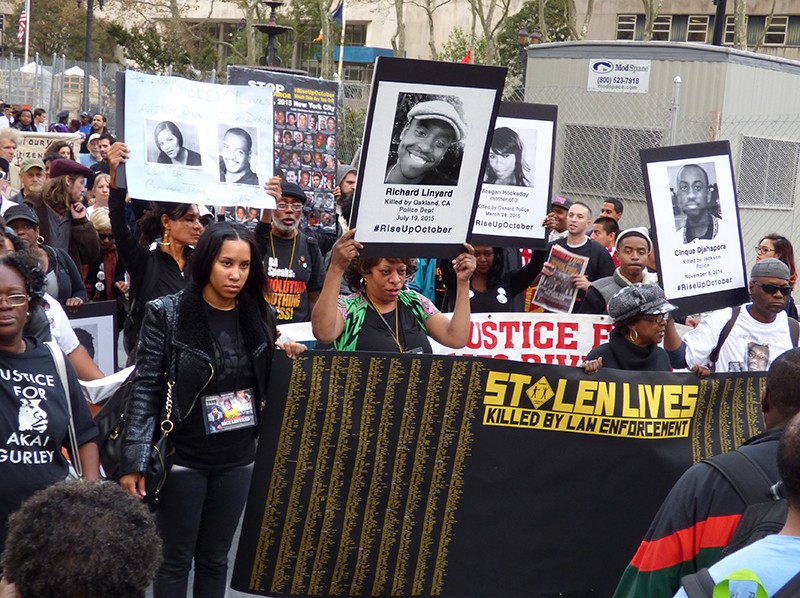 Relatives of people killed in confrontations with the police marched along Court Street photos of their lost family members. Front row right is activist Minnie Bailey; second row center is Carl Dix, founding member of the Revolutionary Communist Party, U.S. Photo by Mary Frost