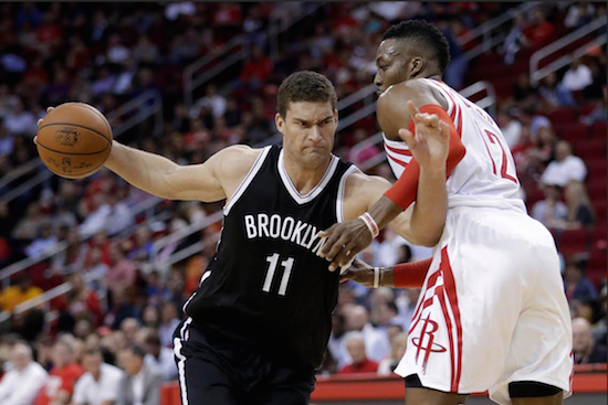 Brook Lopez drives past Dwight Howard Wednesday night in Houston as the Nets used a big fourth quarter to pull out their first win of the season over the Rockets. AP photo