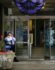 A purple and black bunting hangs over the entrance to the 50th Precinct of the NYPD on Tuesday. Detective Joseph Lemm, a 15-year veteran of the NYPD, was one of six American service members killed Monday in Afghanistan when an attacker rammed an explosives-laden motorcycle into their patrol. AP Photo/Julie Jacobson