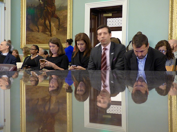 BPL staffers and support members gaze at their cellphones while waiting for the Council committee to convene. BPL President Linda Johnson, center. Photos by Mary Frost