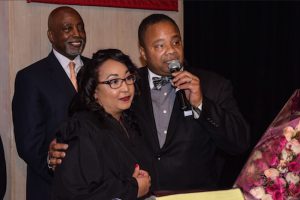 Lorna J. McAllister was sworn in as a judge of the Civil Court of the city of New York during a special ceremony at St. Francis College on Tuesday. Judge McAllister (left) with her husband State Sen. Jesse Hamilton III and father-in-law Jesse E. Hamilton II looking on in the background. Eagle photos by Rob Abruzzese