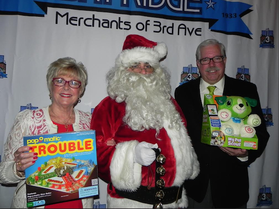 Santa Claus says he is pleased that so many toys were donated for the children of soldiers. Bob Howe, president of the Merchants of Third Avenue, and his wife Diane Howe, led the toy drive. Eagle photos by Paula Katinas