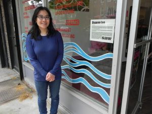 At last year’s SAW event, artist Deanna Lee painted the window of Hair Culture at 7910 Fifth Ave. The blue waves could be waves of hair, but they could also be ocean waves, the artist said. Eagle file photo by Paula Katinas