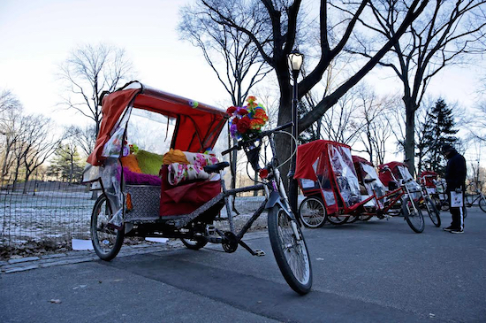 Pedicabs wait for customers in Central Park on Tuesday. A city plan to improve working conditions for Central Park's carriage horses also contains a provision that would protect their turf by banning pedicabs from the parts of the park frequented by tourists. AP Photo/Seth Wenig