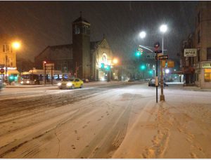 And so it begins — snow flies in front of the Roman Catholic Church of St. Patrick on Friday night. Eagle photo by Lore Croghan