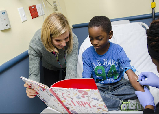 Gabrielle Marden, certified child life specialist and director of New York Methodist Hospital’s Child Life Program, with a patient in NYM’s pediatric emergency room. Photo courtesy of NYM