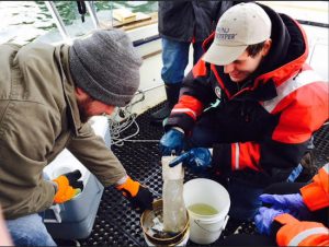 In this March 31, 2015 photo provided by NY/NJ Baykeeper, Mitchell Mickley, left, and Justin Procopio process samples of water just collected from New York Harbor near the Statue of Liberty. A report by NY/NJ Baykeeper says the waterways surrounding New York City are a soup of plastic, ranging from discarded takeout containers down to tiny beads that end up in the food supply. Sandra Meola/NY/NJ Baykeeper via AP