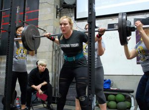 Heavy lifter Charlie Nagle does a squat in last year’s Iron Maidens weightlifting competition. Photo courtesy of CrossFit South Brooklyn