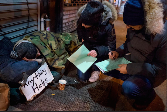 Victoria Parker, center, and Edward Casabian, both of New York and working with The Robin Hood Foundation, an organization that helps the poor, speak to a homeless person as they take part in a count and survey of homeless persons on the streets of New York early Tuesday. Hundreds of people fanned out across the city to conduct the survey just after midnight. AP Photo/Craig Ruttle