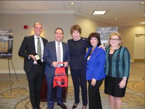 Dr. Kathleen Cashin (center) receives a bottle from Brooklyn Winery as a gift from Brooklyn Chamber of Commerce President and CEO Carlo Scissura (second from left) and Board Chairperson Denise Arbesu (second from right). John Stires (left) is the owner of Brooklyn Winery. At right is Joni Yoswein, of Yoswein New York. Eagle photo by Paula Katinas