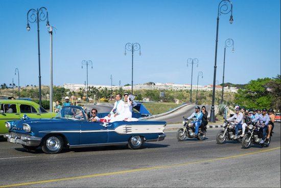 This bride and groom celebrate their wedding day from the back of a classic American car, because why drive around in Cuba in a normal car during your wedding day? Eagle photos by Rob Abruzzese