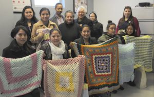 Moms who received the hand-made baby blankets are pictured with the Sunset Park seniors who made them and with officials from NYU Lutheran Family Health Centers. Photo courtesy of NYU Lutheran