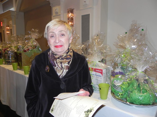 Mary Ann Walsh, administrator of the scholarship fund, inspects the gift baskets that guests would be bidding on at the luncheon. Eagle photos by Paula Katinas