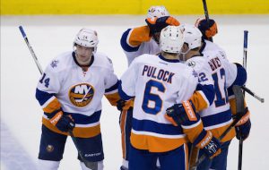 Thomas Hickey (left) and his teammates celebrate what proved to be the game-winning goal as the New York Islanders snuck past the Vancouver Canucks, 3-2, on Tuesday night, improving to 4-1 on their season-high seven-game road trip. AP photo