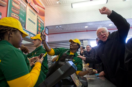 Democratic presidential candidate, Sen. Bernie Sanders, I-Vt., gestures to the crowd while ordering a hot dog at Nathans Famous in Coney Island on Sunday. AP Photo/Mary Altaffer