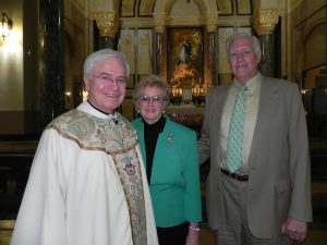 The Rev. Msgr. Kevin Noone enjoys catching up on old times with Claire and Bob Palmer. Eagle photo by Paula Katinas