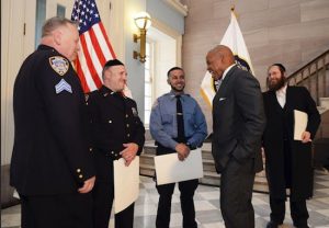 Borough President Eric Adams shares a laugh with Sgt. Frederick Manney, Officer Nuchem Schwartz, and Cadet Elijah Satos (left to right) as Shloime Kohn (far right), honored as April’s “Hero of the Month,” looks on. Photo by Erica Sherman/Borough President’s Office