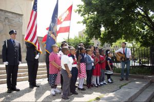 Joseph Fuscia (right, with guitar) leads students of the Brownsville Ascend Charter School in singing “God Bless America.” Eagle photos by Francesca N. Tate