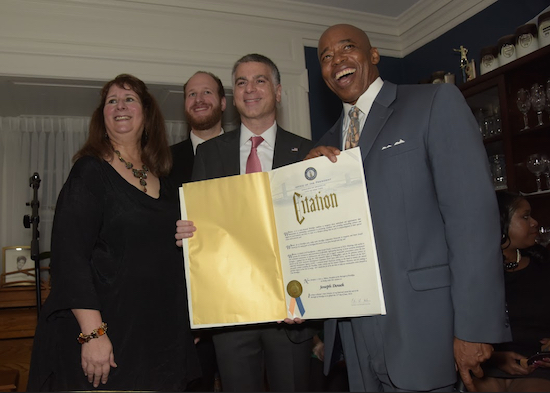 From left: Host Lori Knipel, City Councilmember David Greenfield, City Planning Commissioner Joseph Douek and Brooklyn Borough President Eric Adams show Douek’s official proclamation. Eagle photos by Andy Katz