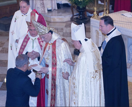 Patriarch Rai (center) receives the gifts of bread and wine to be consecrated into Holy Communion in a Mass that he concelebrated. He is pictured with his concelebrants, left to right: Monsignor James Root, dean of Our Lady of Lebanon Cathedral; Archbishop Paul N. Sayah, Patriarchal Vicar General; Bishop Gregory Mansour of the Eparchy of Brooklyn. Assisting them is Chorbishop Michael Thomas (wearing black cassock). Brooklyn Eagle Photo by Francesca N. Tate
