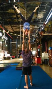 Angela Buccinni, owner of The Muse Brooklyn in south Bushwick, does a dramatic handstand with support from acrobatics coach Yoni Kallai. Eagle photos by Lore Croghan